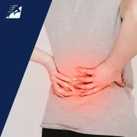 Eine Frau greift sich auf den schmerzenden Rücken