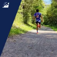 Ein Läufer von hinten beim schnellen Laufen auf Schotter