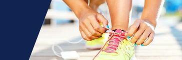 Eine Läuferin bindet einen Laufschuh