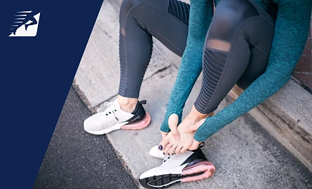 Eine Frau mit einem Fusskrampf beim Laufen