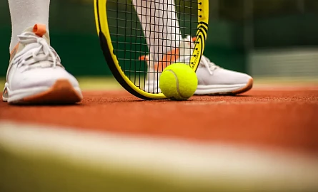 Ein gelber Tennisschläger mit einem Tennisball