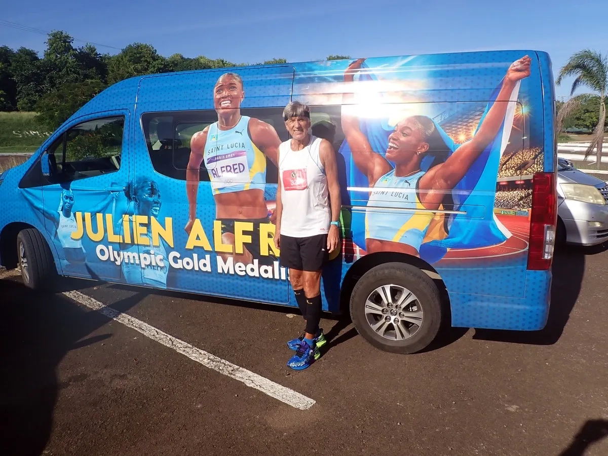 Eastern Caribbean Marathon Challenge: der Autor vor dem Bus mit einem Konterfei von Julien Alfred