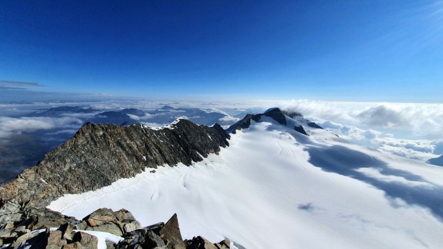 Bernina-Überschreitung 74: Der Piz Zupo ist erreicht und die nächsten Gipfel in Sicht. Der lange Bellavista-Grat, weiter im Hintergrund Piz Spinas und hinter den Wolken versteckt Piz Palü
