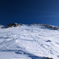 Skitour Hippoldspitze 11: Der Wind hat im Schlussabschnitt den gesamten Schnee verblasen. Nach einem Stück mit Harscheisen, geht es im Schlussteil nur noch ohne Skier weiter.
