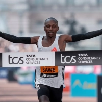 London Marathon 2025: Sabastian Sawe (KEN) reißt die Arme in die Höhe, als er die Ziellinie auf der Mall überquert und London Marathon gewinnt.